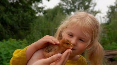 Tatlı sarışın kız kızıl bir fıstığı okşuyor. 