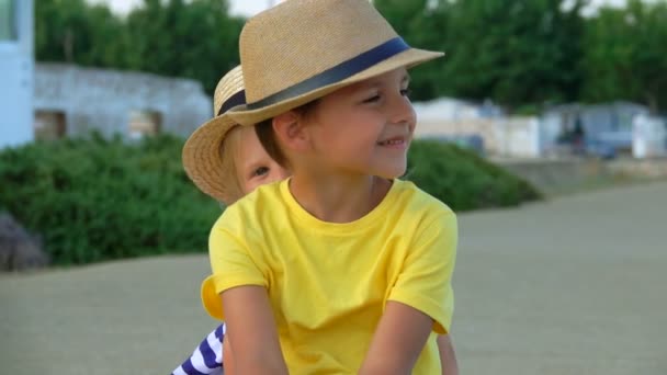 可爱的小男孩和戴草帽的小女孩坐在一起 — 图库视频影像