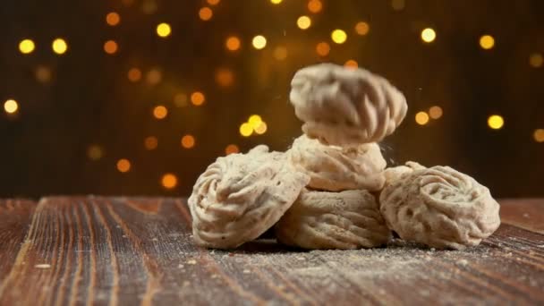 Meringue koekjes vallen op een houten ondergrond — Stockvideo