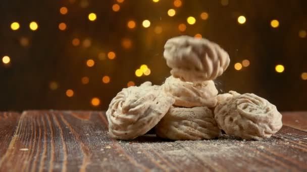 Galletas de merengue están cayendo sobre una superficie de madera — Vídeos de Stock