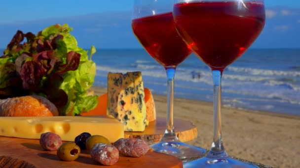 Pique-nique romantique au bord de la mer avec vin rouge dans les verres — Video