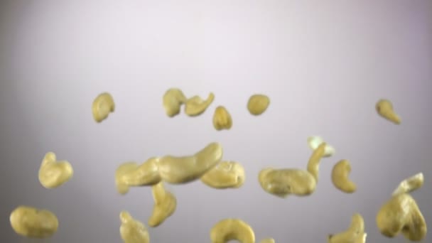 Close-up van cashewnoten vliegen op een witte achtergrond — Stockvideo