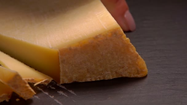 Primer plano del queso parmesano envejecido duro cortado con un cuchillo en rodajas — Vídeo de stock