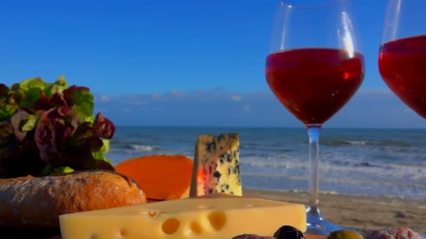 Panorama de um piquenique romântico à beira-mar com vinho tinto, vários tipos de queijo — Vídeo de Stock