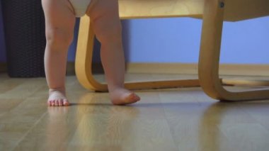 Kameraya doğru yürüyen tombul ayaklı bir bebeğin alçak açılı görüntüsü.