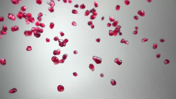 Соковиті зерна стиглого граната падають по діагоналі з краплями води — стокове відео