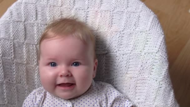 Piccolo bambino carino su una coperta bianca sta sorridendo alla fotocamera — Video Stock