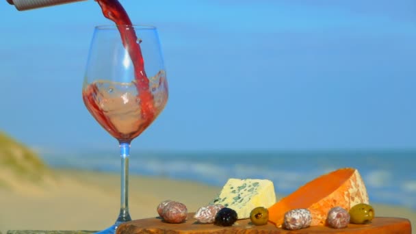 Il vino rosso viene versato nel bicchiere accanto ai vari tipi di formaggio. — Video Stock
