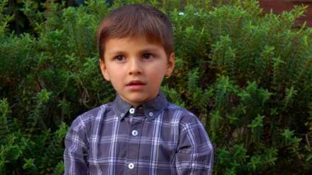 Heureux garçon saute et compte sur les doigts à l'extérieur