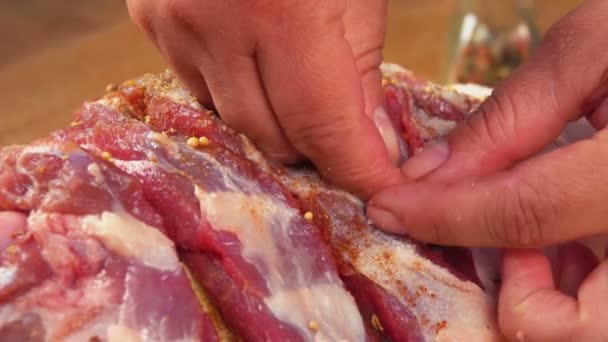 As mãos estão enchendo uma perna de carne crua com alho — Vídeo de Stock