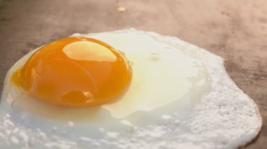 Düz ızgara yüzeyinde yumurta kızartılıyor.