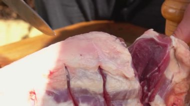 Büyük bir bıçakla kesilmiş çiğ et yakın plan.