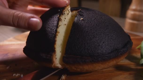 Mão leva um pedaço de torta de queijo Tourteaux Jahan cottage preto — Vídeo de Stock