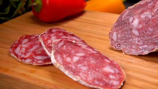 Крупный план сухой колбасы в белой коже, разрезанной на ломтики ножом — стоковое видео