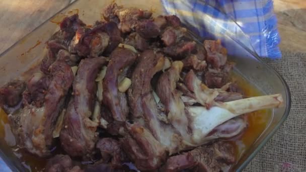 Deliciosa carne de cordero preparada en bandeja de vidrio se coloca en la mesa de madera — Vídeos de Stock