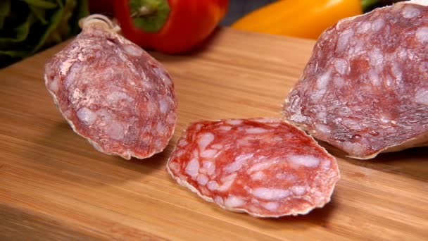 Salsiccia secca in pelle bianca tagliata a fette con coltello su tavola di legno — Video Stock