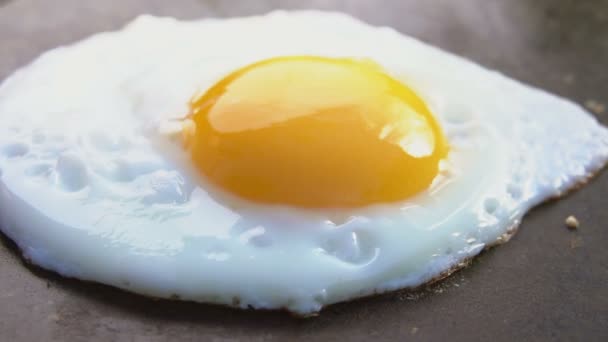 Super close-up of the fried egg taken from the flat grill surface — Stock Video