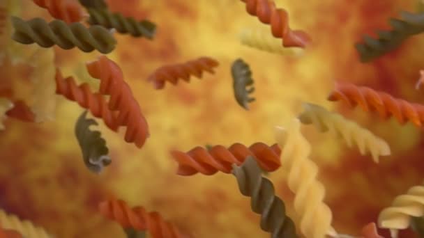 Färgad pasta fusili flyger diagonalt på en gul ochre bakgrund — Stockvideo
