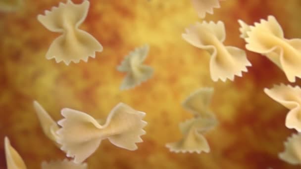 Pasta seca Farfalle vuela diagonalmente sobre un fondo ocre amarillo — Vídeos de Stock