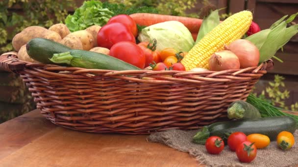 Wiklinowy kosz pełen warzyw na drewnianym stole — Wideo stockowe