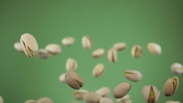 Primer plano de pistachos rebotando sobre el fondo verde oliva — Vídeo de stock