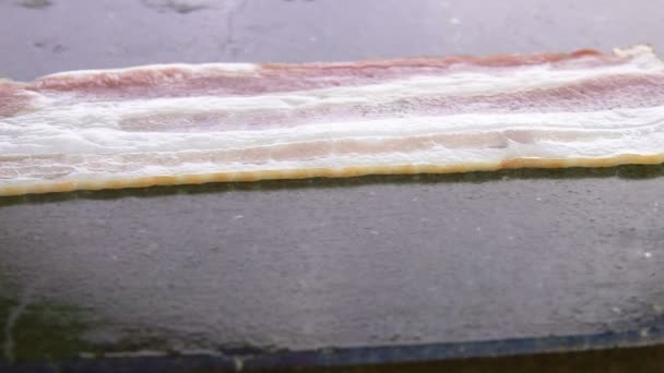 Närbild av läckra bacon band stekning och steka platt grill yta — Stockvideo