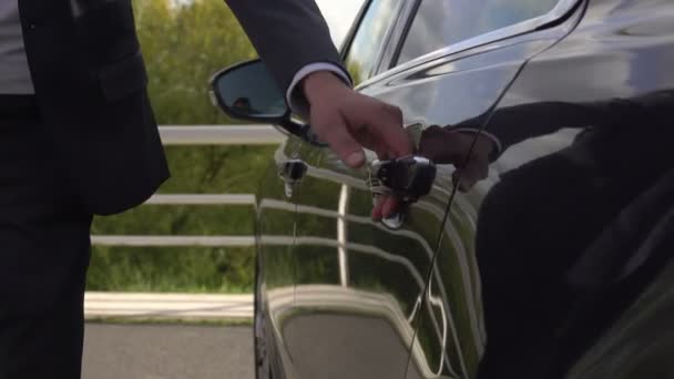 Личный водитель открывает автомобильную дверь для клиентки — стоковое видео