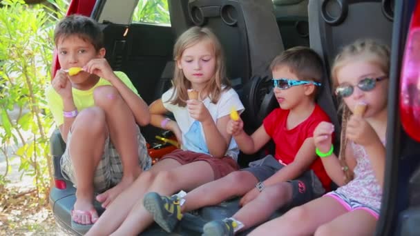 Crianças alegres em roupas coloridas estão comendo delicioso sorvete — Vídeo de Stock