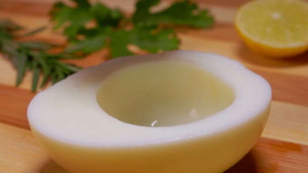 Close-up of delicious black caviar falling into the halved white of an egg — Stock Video