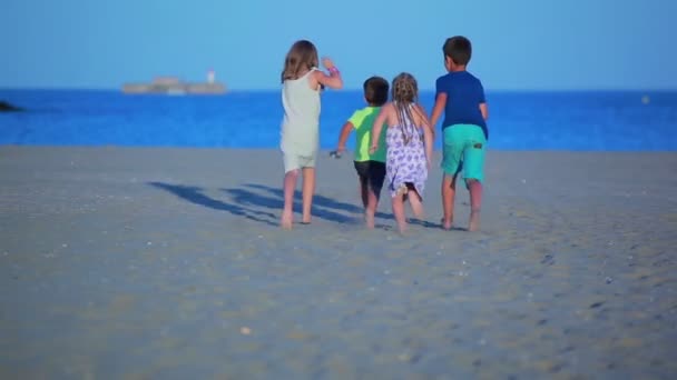 Счастливые веселые дети бегут по песчаному пляжу — стоковое видео