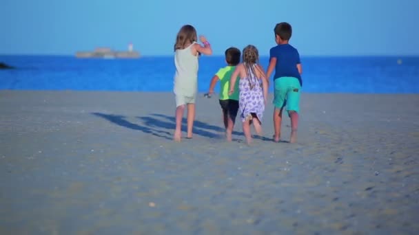 Felices niños alegres corren por la playa de arena — Vídeos de Stock