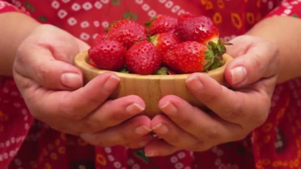 Les mains féminines montrent un bol avec des fraises rouges juteuses — Video