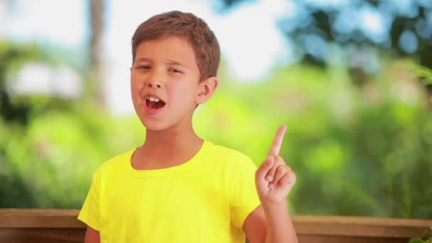 O rapaz alegre ameaça zombeteiramente com um dedo — Vídeo de Stock