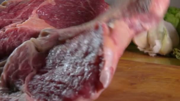 Stück rohes Fleisch fällt auf das Holzbrett — Stockvideo