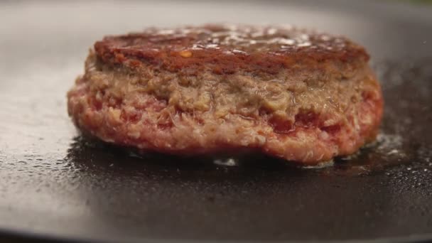 Nahaufnahme vom Rinderschnitzel für einen Burger, der mit einem Spachtel auf den flachen Grill gepresst wird — Stockvideo