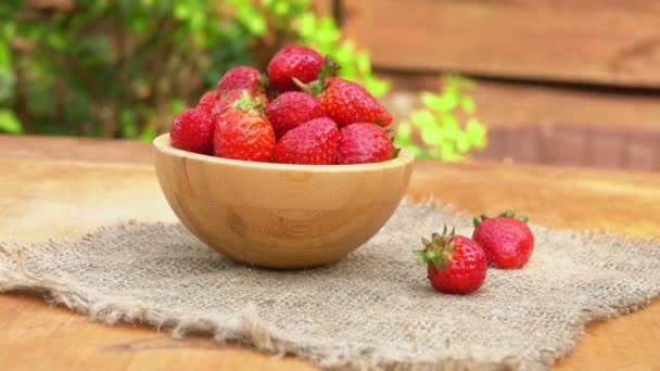 Panorama of the wooden bowl with juicy red strawberries on the burlap napkin — Stock Video