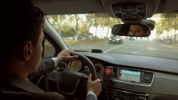 Un conductor personal guapo está conduciendo el coche por las calles de la ciudad — Vídeos de Stock