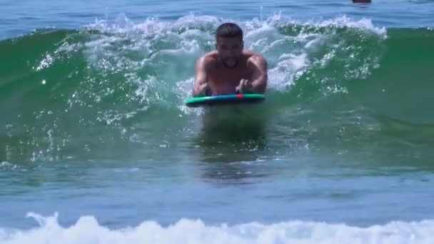 Joven hombre guapo está nadando en las olas del mar surf — Vídeos de Stock