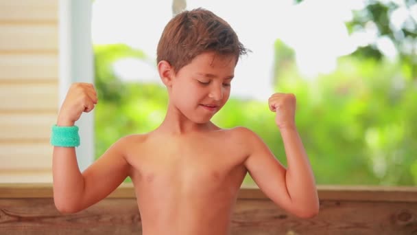 De zelfverzekerde jongen toont spieren. — Stockvideo
