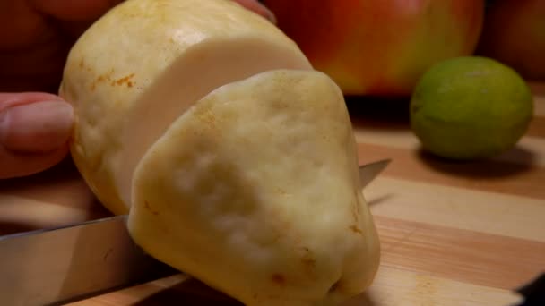 Nůž rozřeže exotickou Guavu na kulaté plátky na řezací desce — Stock video