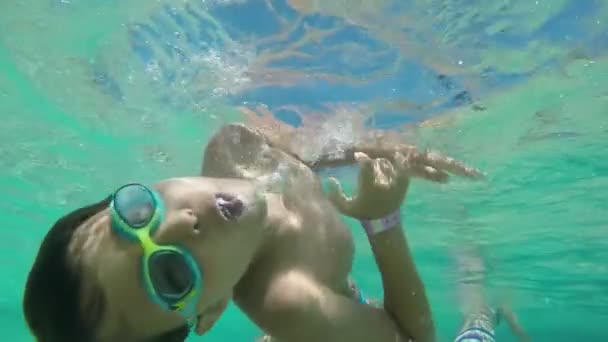 Chłopiec w goglach kąpielowych wiruje pod wodą — Wideo stockowe
