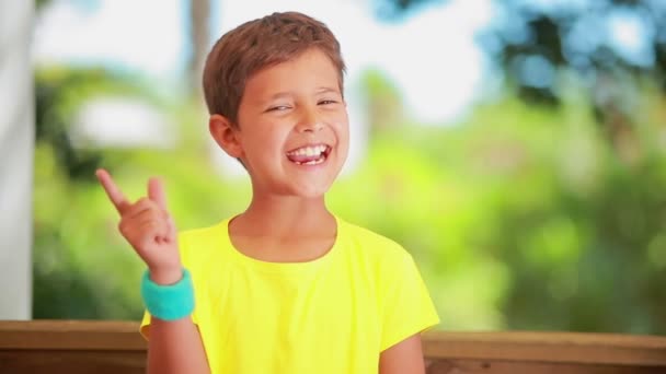 明るい男の子は笑顔と指であざやかに脅かす — ストック動画