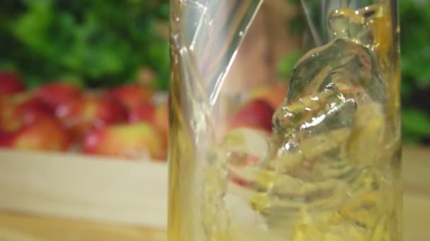 Смачний свіжий яблучний сік вливають у скляний глечик — стокове відео