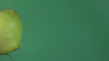 İki büyük olgun yeşil elma yeşil zeminde çarpışıyor. 