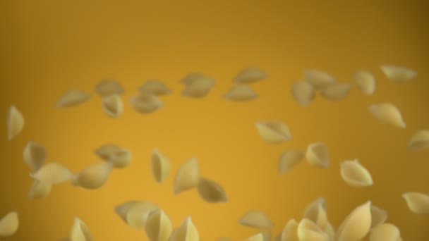 Pasta seca Conchiglie rigate está volando hacia arriba y girando sobre un fondo amarillo — Vídeos de Stock