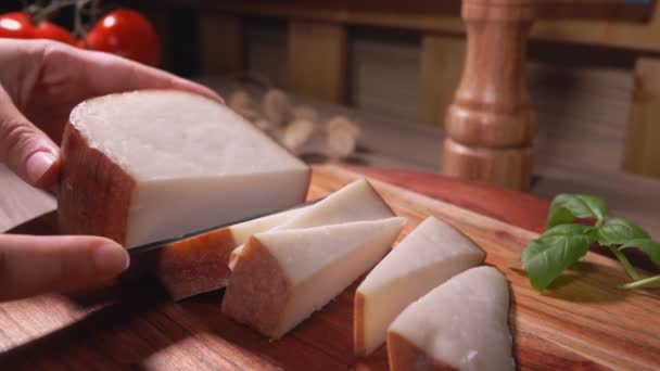 El primer plano de las manos cortando un queso de oveja semi duro en trozos — Vídeo de stock