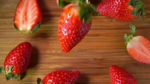 Fraise mûre tombe sur la surface en bois et se brise sur les quatre morceaux — Video