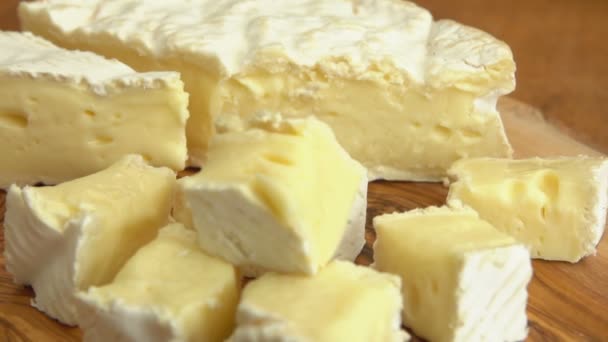 Super primer plano de un delicioso queso brie suave cortado en los cubos — Vídeo de stock