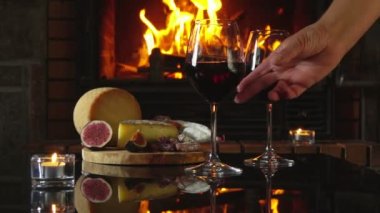 El, siyah masadan çeşitli aperatiflerle birlikte bir bardak kırmızı şarap alır.
