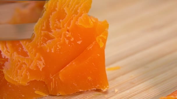 Pisau memotong jeruk keras berwarna keju Mimolette di papan kayu — Stok Video